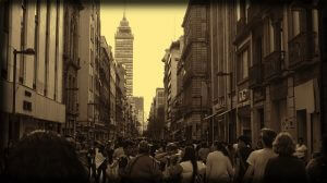 Personas caminando por las vibrantes calles de la Ciudad de México con edificios modernos e históricos de fondo.