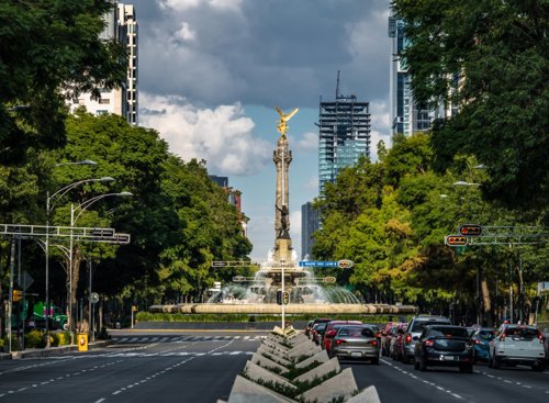 Ángel de la Independencia en la CDMX, con un cielo vibrante y detalles arquitectónicos icónicos.