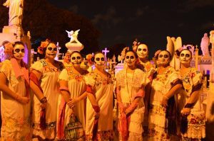 People with skull faces and traditional costumes, celebrating the Day of the Dead in Mexico with pride and respect for their ancestors